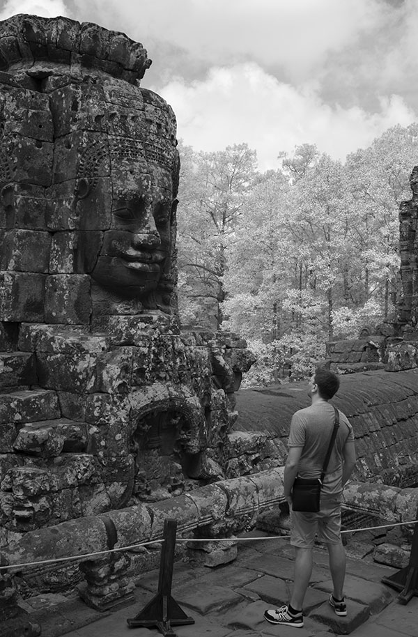 European Tourist Contemplating One of the Faces of Buddha, Bayon Temple.